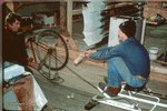 1981 Dick Dreissigacker and Jon Williams. Peter and Dick Dreissigacker create a winter training device for rowers. They nail an old bike to the floor of the barn and pull on the chain. Courtesy of C2. - Click for full-size image!